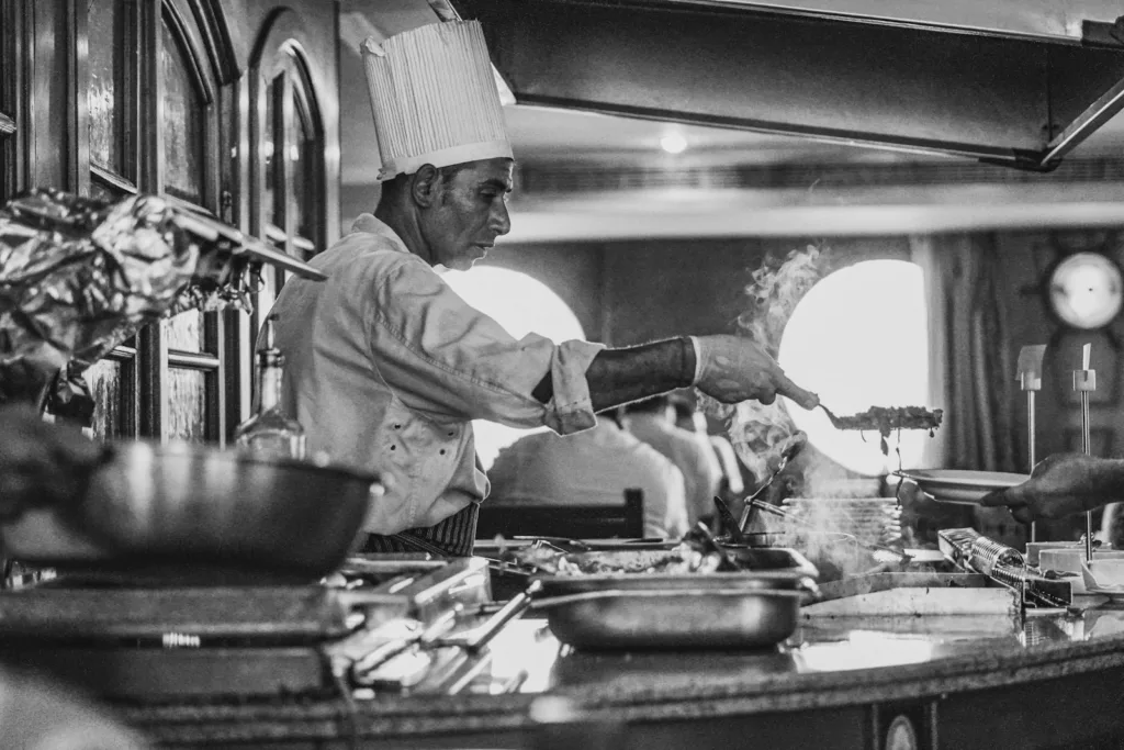 grayscale photo of man cooking - libros de cocina clásicos