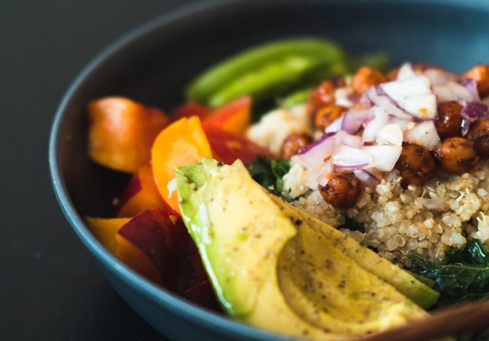 Los 10 Mejores Libros de Cocina Vegana Sostenible - a blue bowl filled with rice and veggies