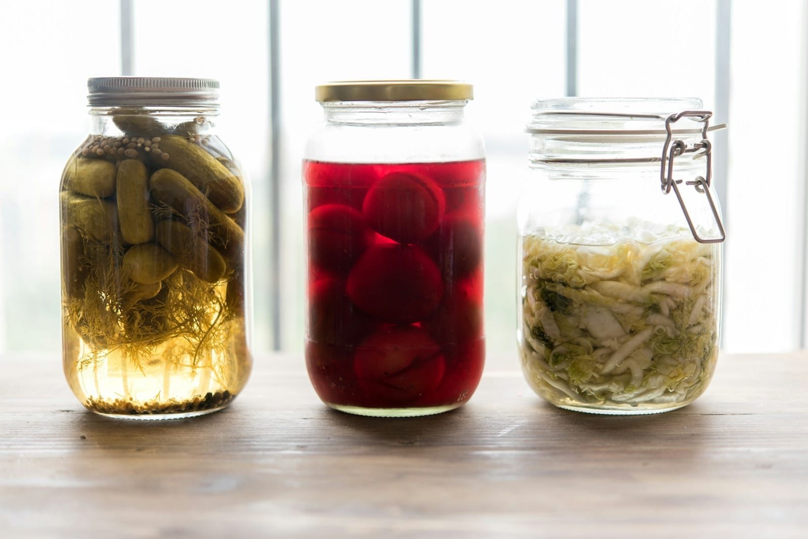 three jars filled with different types of food - Los 10 Mejores Libros de Fermentación Casera para Principiantes